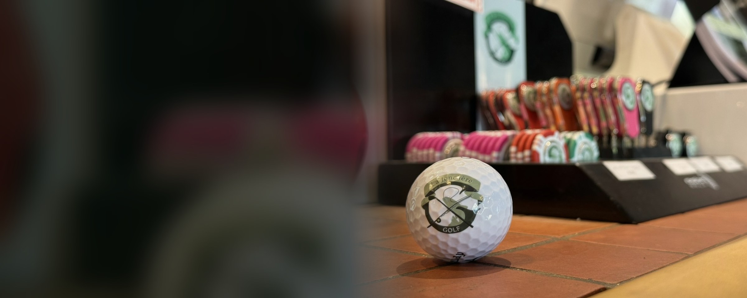 Une balle aux couleurs du Golf de la Jonchère, devant les relève-pitchs du Pro Shop